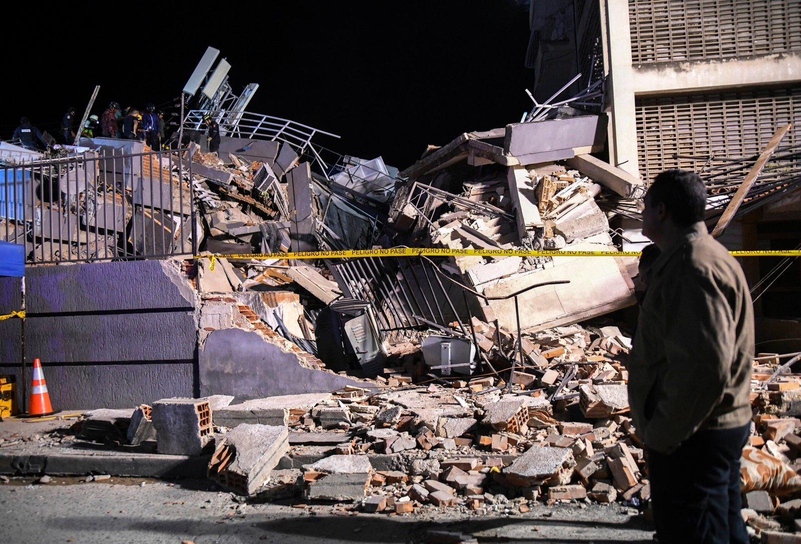 Emergency rescue teams pulling survivors from the rubble of a heavily damaged residential building in La Guaira, Venezuela, following the devastating twin earthquakes.