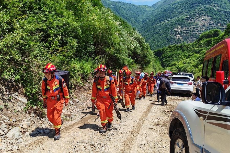 Rescue personnel and excavators work at the site of a landslide in a remote mountainous area of northwestern China, where 21 forestry workers were killed after being buried by debris.