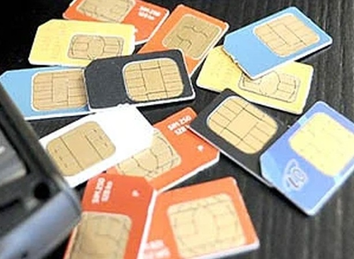 A customer service executive at a telecom store verifying subscriber documents before issuing a new SIM card