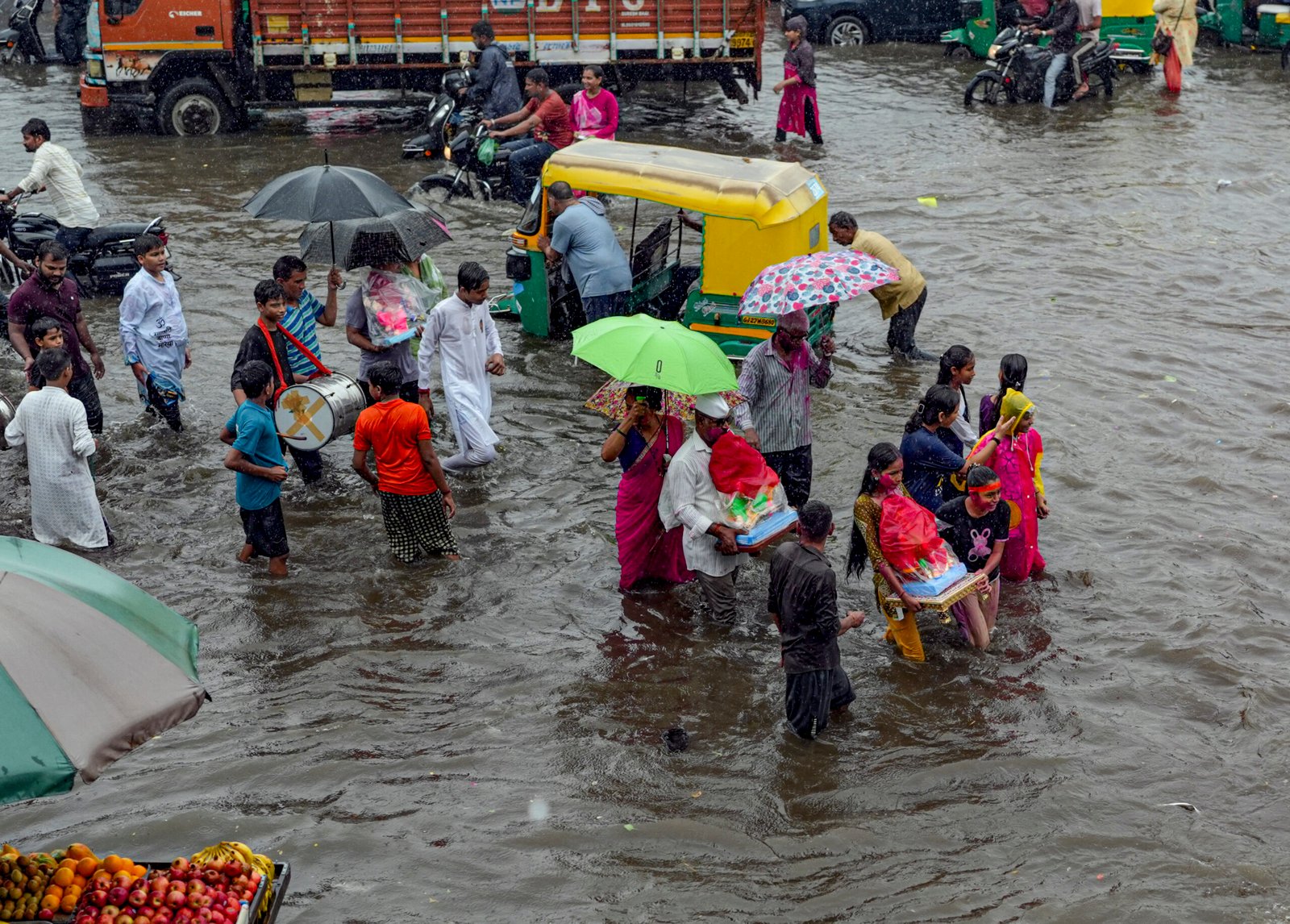 Vehicles navigate knee-deep water on flooded roads as torrential rains throw normal life out of gear across Gujarat.