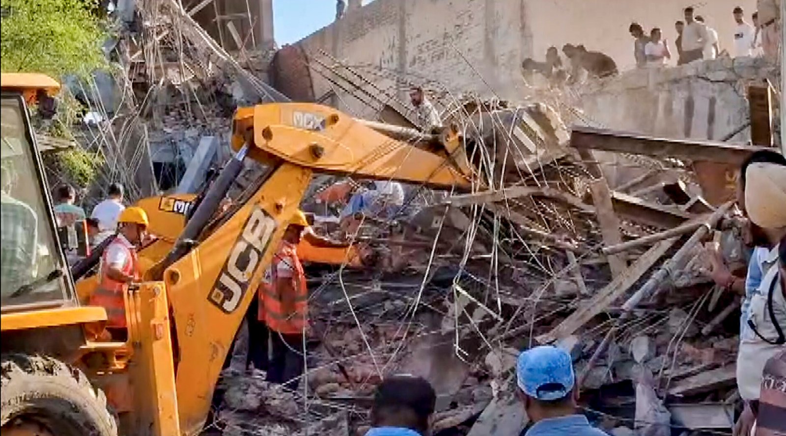 rescue workers search through debris at ambala building collapse site
