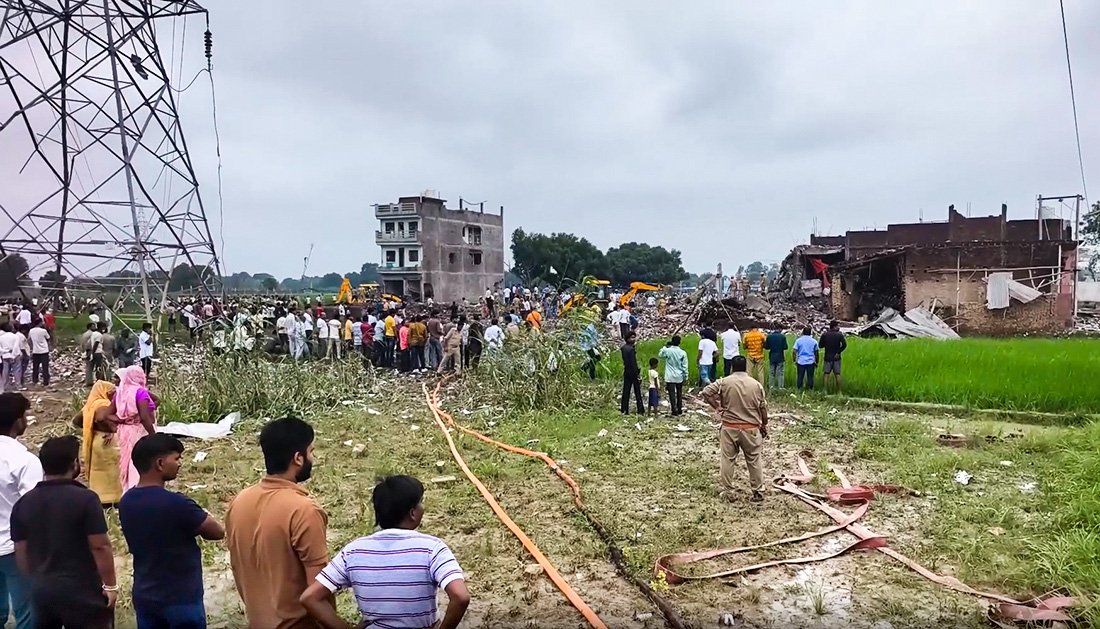 UP Police personnel patrolling and investigating the crime scene following an encounter with the main accused in the Kaushambi factory blast